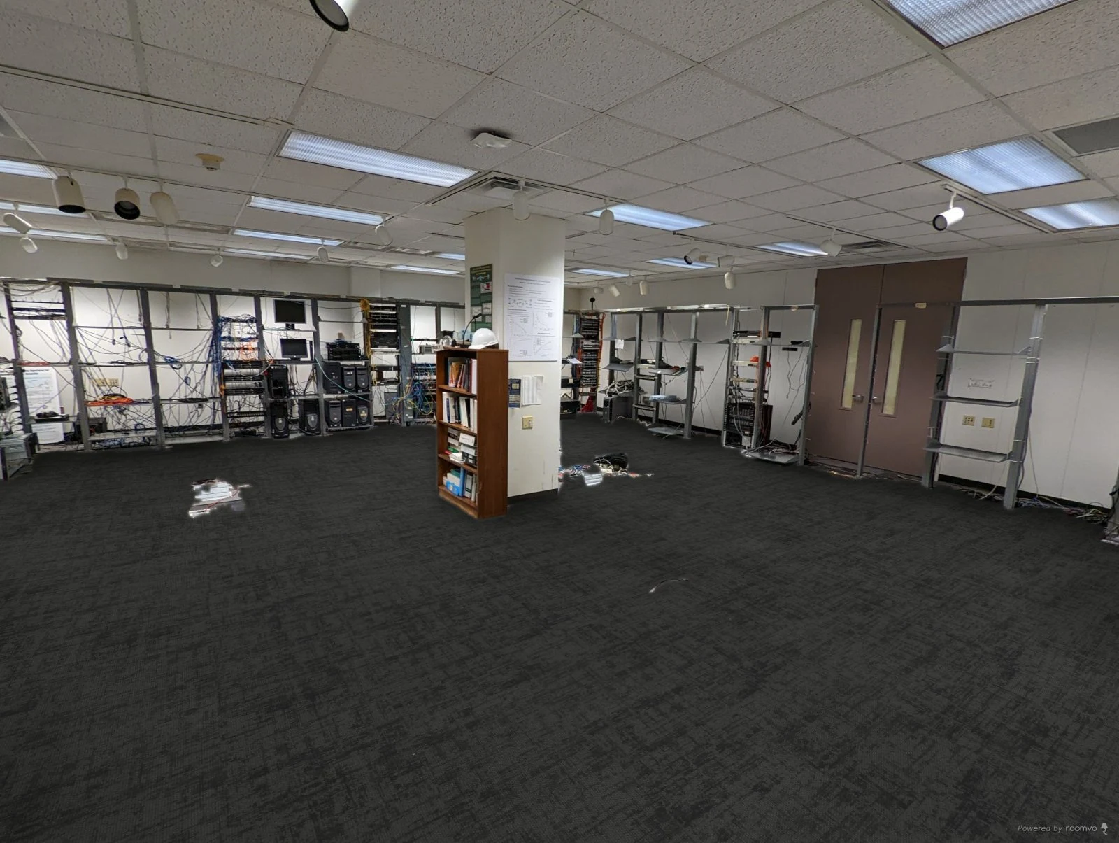 Historical simulation of dark carpet in the unrenovated room, with equipment racks and a bookcase still in place